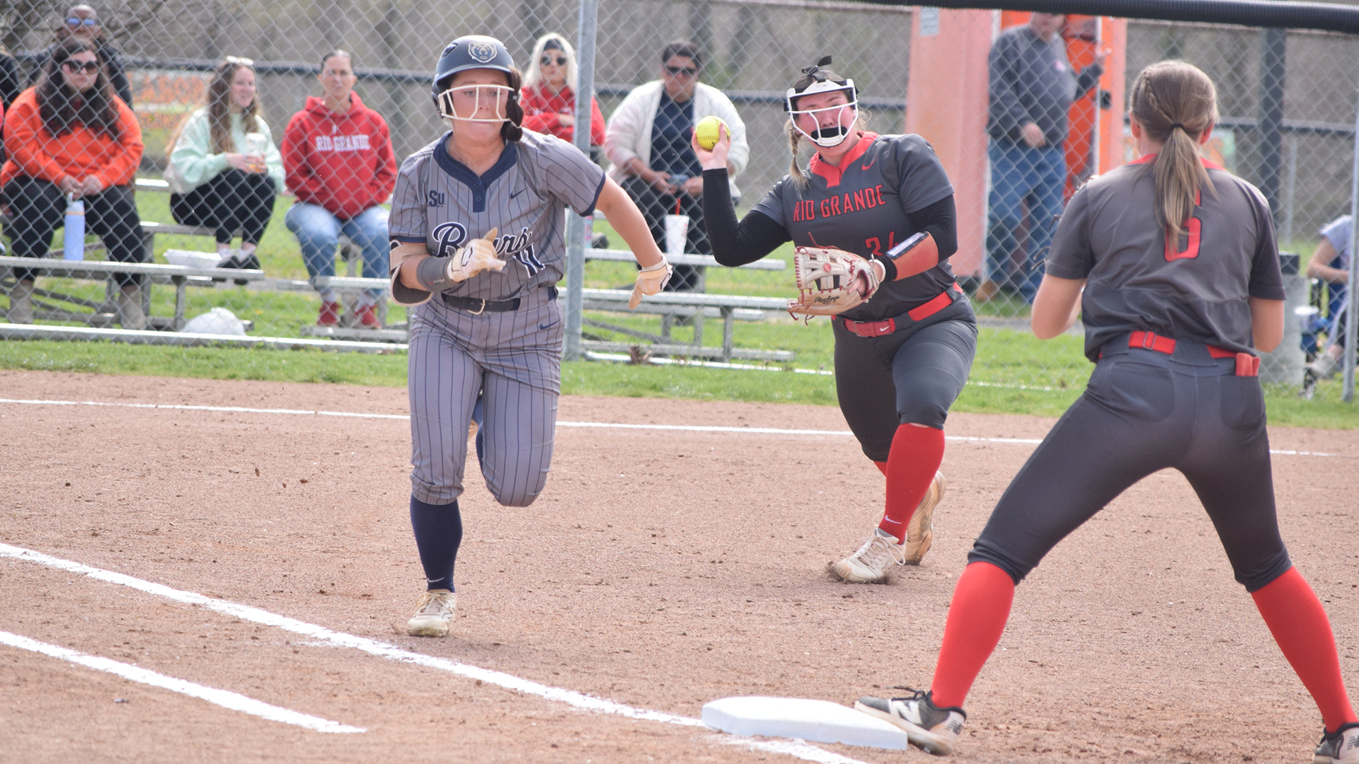 Rio Grande's Macy Kise throws toward first base in an attempt to retire Shawnee State's Jenna Christopher during game on of Sunday's doubleheader at Doc Singleton Park in West Portsmouth, Ohio.