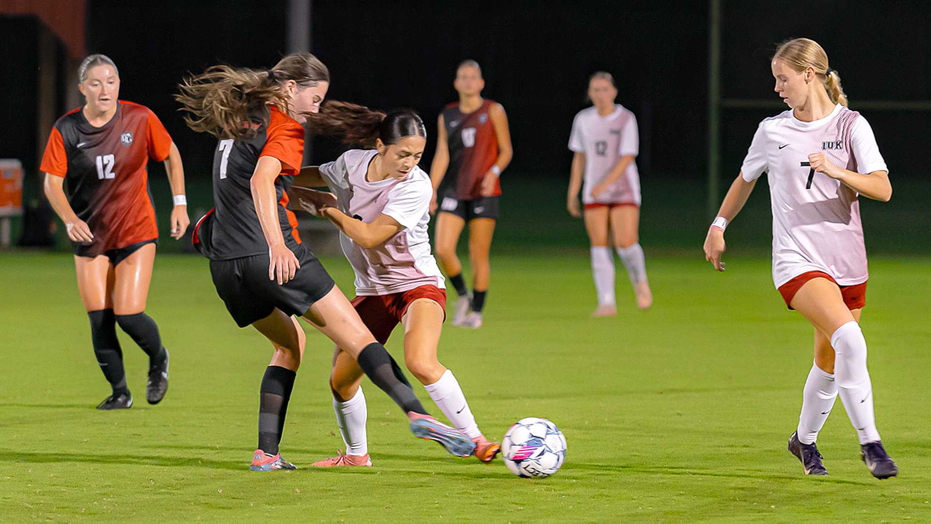 Rio Grande's Lexi Boyd tries to send a pass between a pair of Indiana University Kokomo defenders during the RedStorm's 0-0 tie with the Cougars, Saturday night, at Evan E. Davis Field.