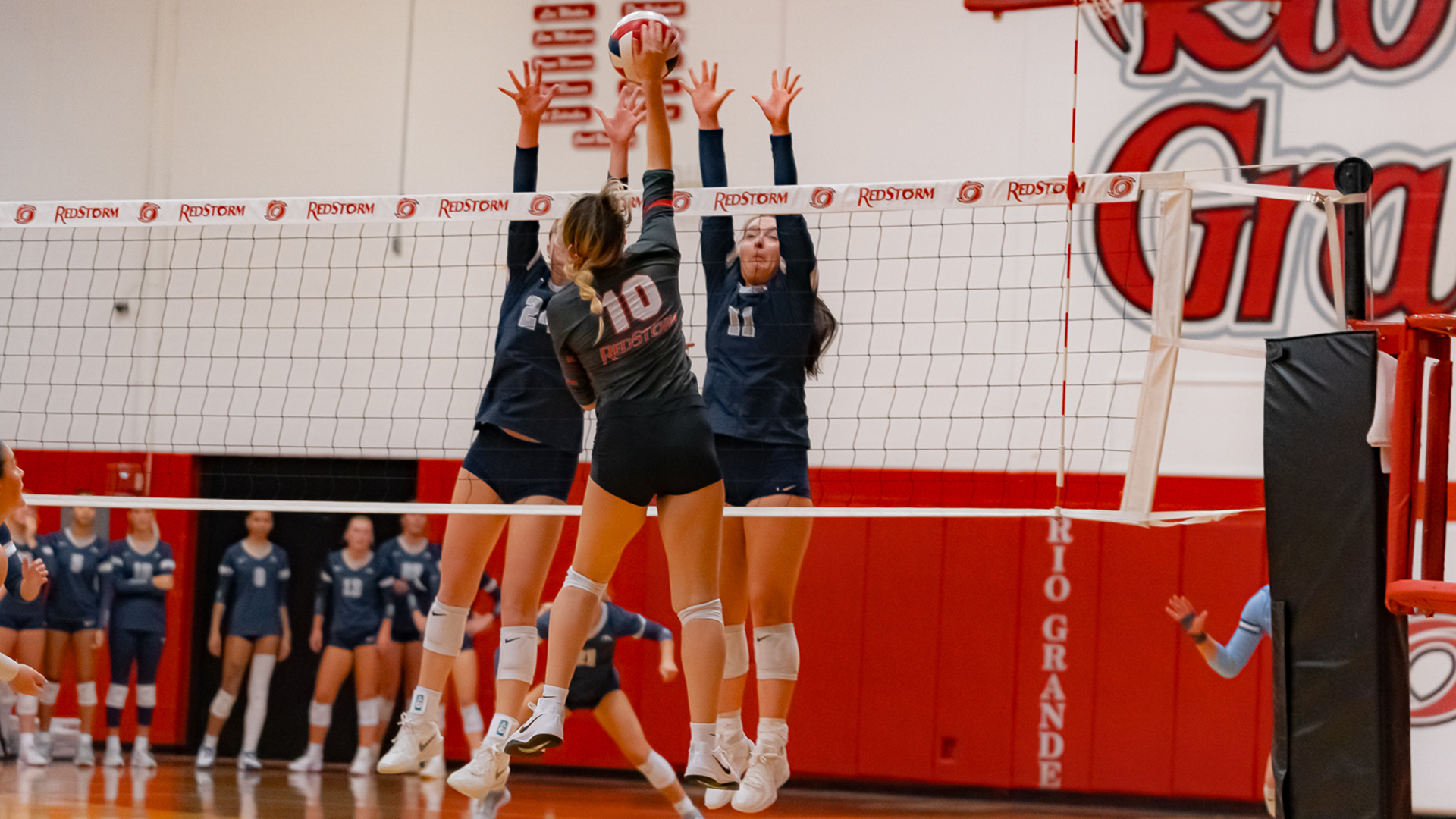 Rio's Olivia Smith sends an attack past two Shawnee State defenders during Saturday's match at the Newt Oliver Arena.
